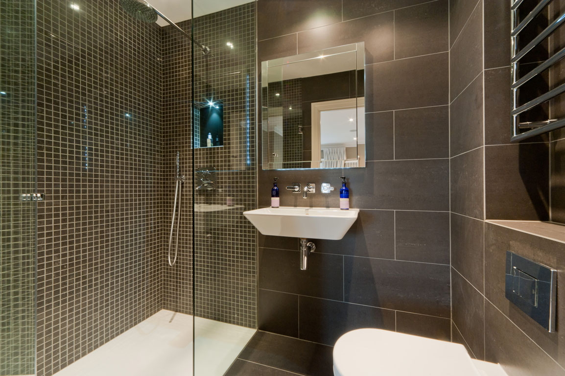 decoración brillante de un baño con ducha en colores oscuros