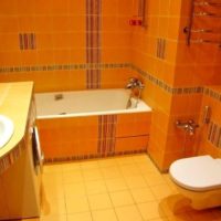Photo de l'intérieur de la salle de bain combinée dans des tons de carotte