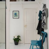 Couloir blanc et chaise haute bleue