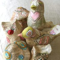 Figures de journal en papier mâché représentant des oiseaux