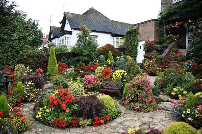 Jardin fleuri devant le porche d'un immeuble