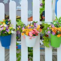 Pots de fleurs lumineuses sur une clôture en bois