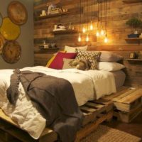 Lit sur de vieilles palettes dans une chambre rustique