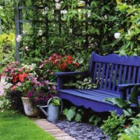 Banc bleu derrière une pergola en bois