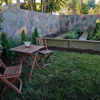 Des chaises en bois pliantes et une table sur une pelouse verte