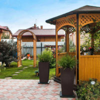 Coin de repos dans un jardin de pays avec une petite tonnelle