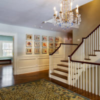 Escalier en bois avec balustrade blanche dans le hall d'une maison de campagne