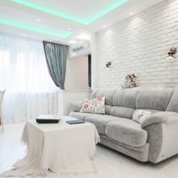Papier peint sous une brique blanche derrière un canapé dans le salon