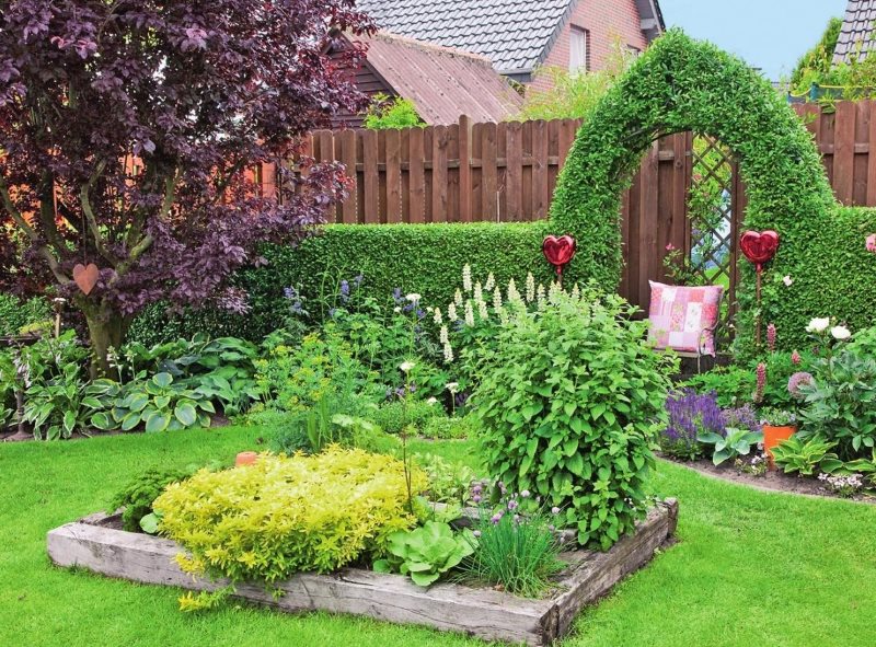 Parterre de fleurs en bois sur la pelouse devant l'entrée du jardin