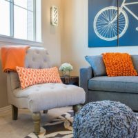 Coussin orange dans une chambre aux couleurs pastel