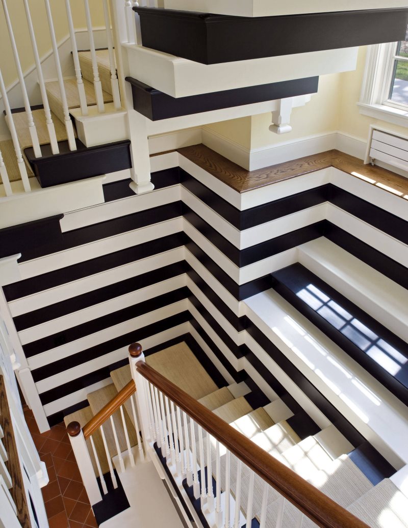 Conception d'escalier à rayures dans une maison de campagne de trois étages