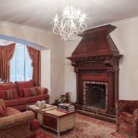 Tonos oscuros de rojo en la sala de estar con chimenea.