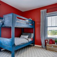 Cama azul en una habitación infantil roja