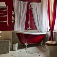 Cortinas blancas en una bañera roja.