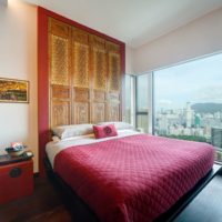 Colcha roja en una cama en un dormitorio de un edificio de varios pisos