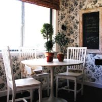 Mesa de comedor blanca con plantas vivas en la cocina de un apartamento de la ciudad