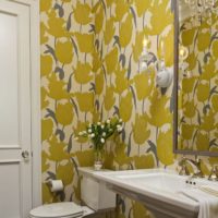 Papel tapiz amarillo con flores en el baño.