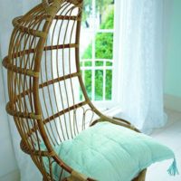 Chaise en osier suspendue avec un oreiller à la menthe
