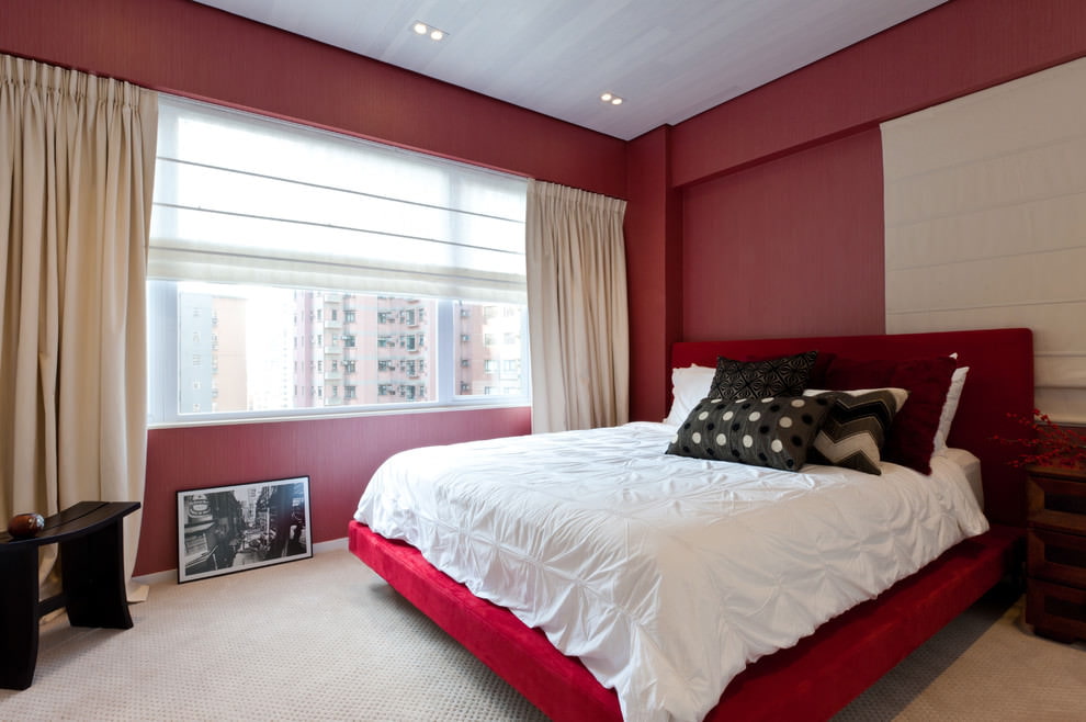Interior de dormitorio minimalista con paredes rojas.