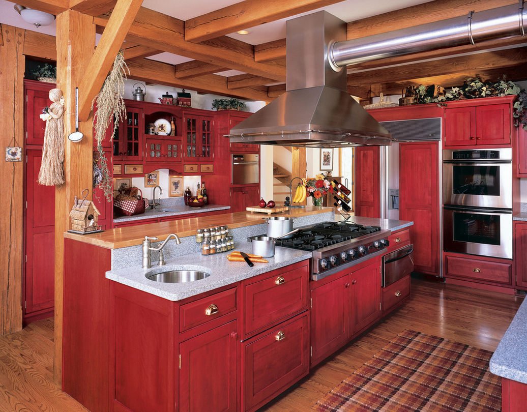 El interior de la cocina en estilo rústico con predominio del rojo.