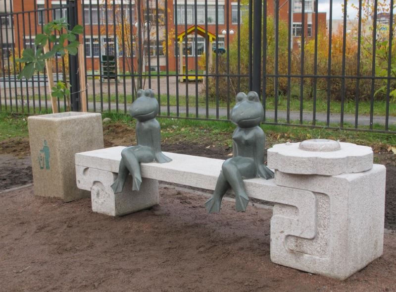 Figures de grenouilles assis sur un banc décoratif