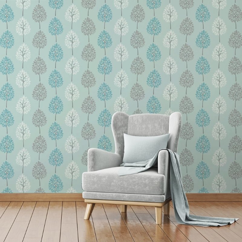 Suave sillón vintage en el fondo de una pared decorada con papel tapiz con adornos naturales.