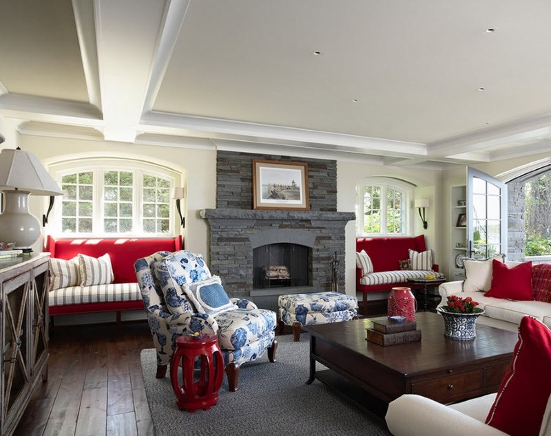 La combinación de tonos rojos, blancos y azules en el interior de la sala de estar con una chimenea gris.