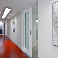 La combinaison du sol rouge et de la porte blanche à l'intérieur du couloir étroit