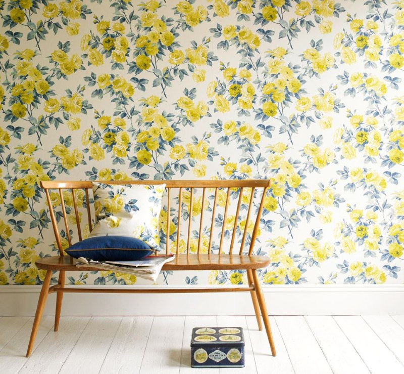 Papel pintado con flores amarillas en la pared de la sala de estar de una casa de campo