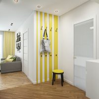 Percha amarilla con ganchos en el pasillo de una casa de campo
