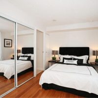 Mur miroir dans la chambre avec lit blanc