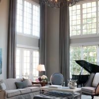 Rideaux gris sur les hautes fenêtres du salon