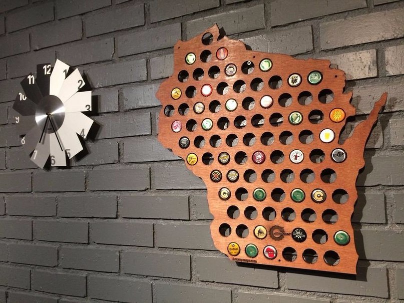 Un panneau sur le mur avec des bouchons de bouteilles de bière