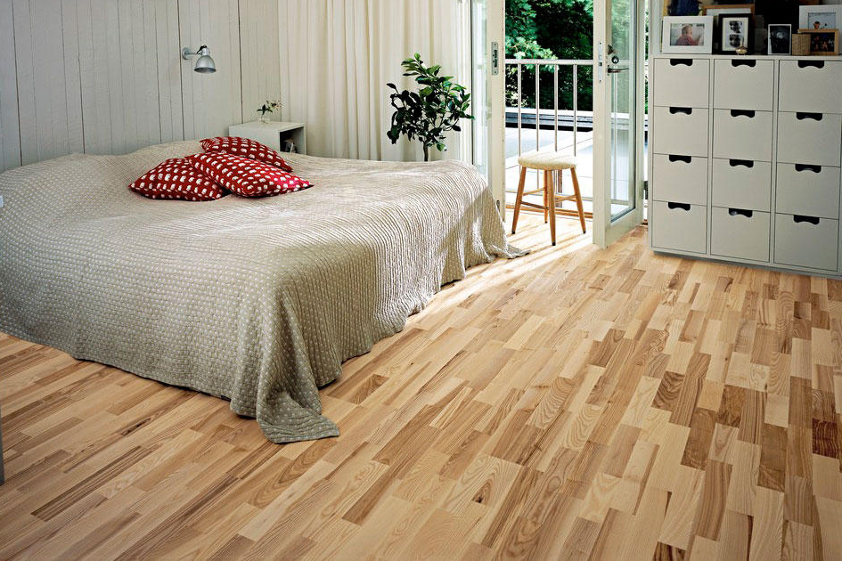 Lit gris sur le parquet de la chambre