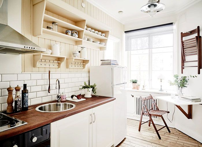 Una pequeña mesa plegable en la pared de una cocina estrecha