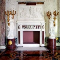 Estatuas cerca de la chimenea en la sala de estar de estilo antiguo