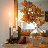 Rameaux avec des feuilles de bouleau séchées dans un vase sur une commode