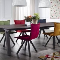 Chaises rembourrées de différentes couleurs dans la salle à manger-cuisine d'une maison privée