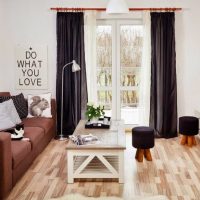 Rideaux noirs dans le salon aux murs blancs.