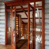 Puertas de madera con vidrio en una pared de troncos
