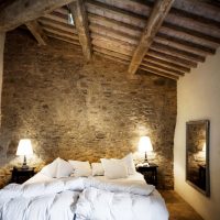 Cama blanca en el dormitorio con techo de madera.