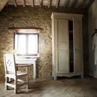 Muebles vintage en una habitación con paredes de piedra.