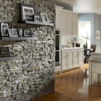 Étagères avec des photos sur le mur avec revêtement en pierre