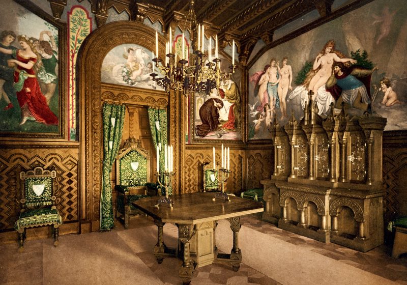 Interior de un antiguo castillo con pinturas en las paredes.