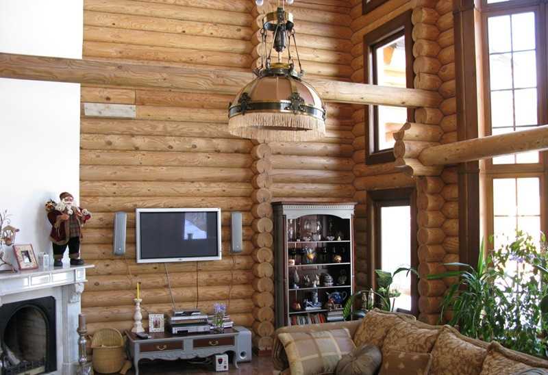 Lampa z dużym błyszczącym sufitem w salonie domu z bali