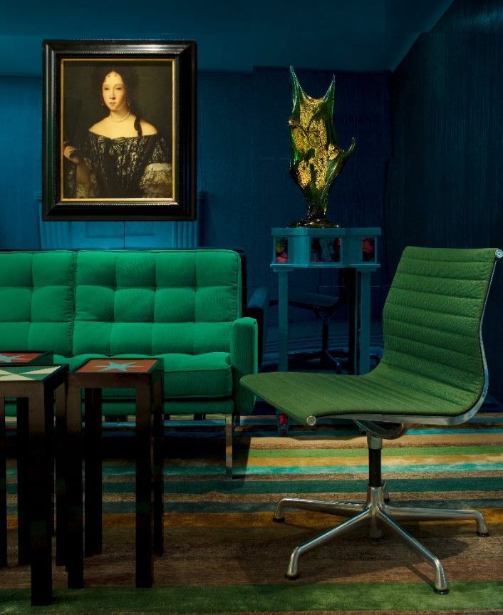 Muebles verdes contra las paredes azul oscuro de la sala de estar