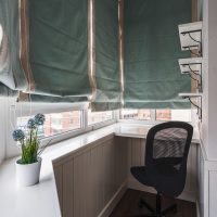 Rideaux romains aux fenêtres d'un petit balcon