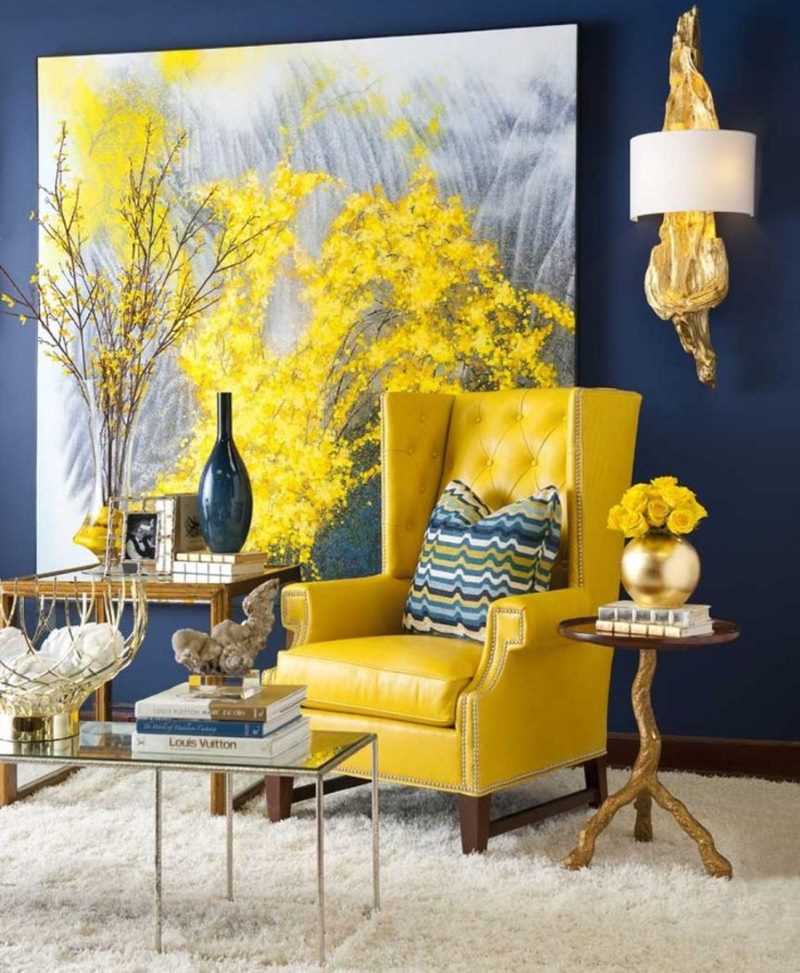 Sillón amarillo contra una pared azul con una imagen.