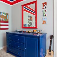 Miroir dans un cadre rouge sur la commode dans le couloir