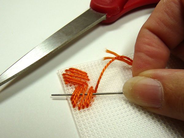 Costura con hilos gruesos sobre un lienzo de plástico.